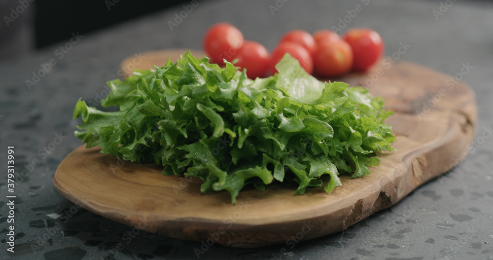 frisee salad leaves on olive board