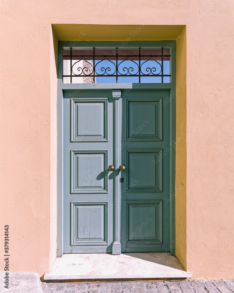 Fototapeta premium Painted wooden external door and colorful wall by the sidewalk, Athens, Greece