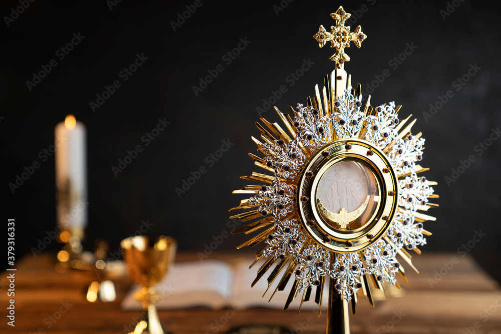 Obraz na płótnie Catholic religion concept. Catholic symbols composition. The Cross, monstrance,  Holy Bible and golden chalice on wooden altar.  w salonie