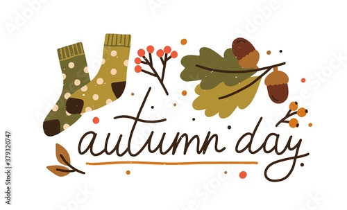 Autumn day colorful lettering with design elements vector flat illustration. Cute fall composition decorated by leaves, acorn, branches, berries and warm socks isolated. Cozy seasonal inscription