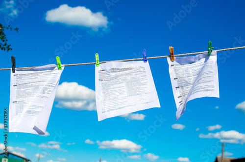 The documents tax forms were washed and dried in the open air by hanging from a clothesline. Concepts of money laundering, legalization of income, concealment of income, tax evasion photo