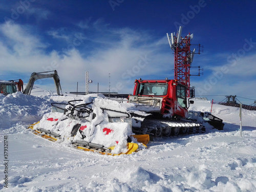 Snow-covered snow removal equipment on the slope of a winter ski resort
