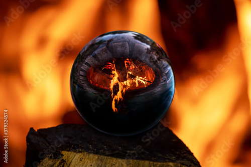 фотографія Campfire in a stone surround hearth reflected in a glass ball