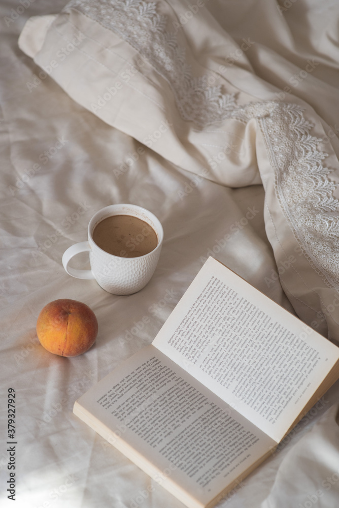 Morning. Cup of coffee, peach and book on the bed. Lifestyle. Mentlhealth. The consept of heathy life. Morning. Cup of coffee, peach and book on the bed. Lifestyle. Mentlhealth. The consept of heathy life.
