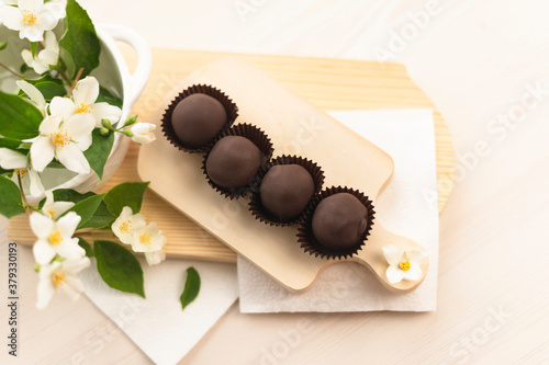 Handmade chocolates on a light wooden background. Chocolate balls raw