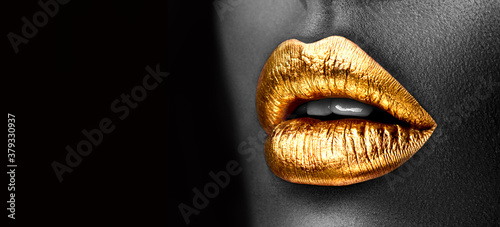 Golden lipstick closeup. Gold metal lips. Beautiful makeup. Sexy lips, bright lip gloss paint on beauty model girl's mouth, close-up. Lipstick. Black and white image