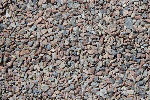 Crushed stone of different colors lies on the road.