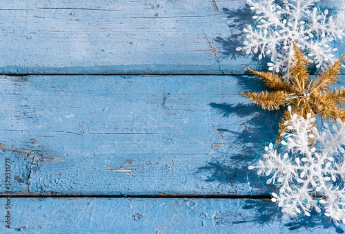 Wooden Christmas background, top view. Place for text on a new year's background. Beautiful blue Christmas horizontal background with white snowflakes and Golden shiny star.
