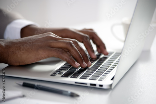 Close-up of hands of african american businessman typing on a keyboard.