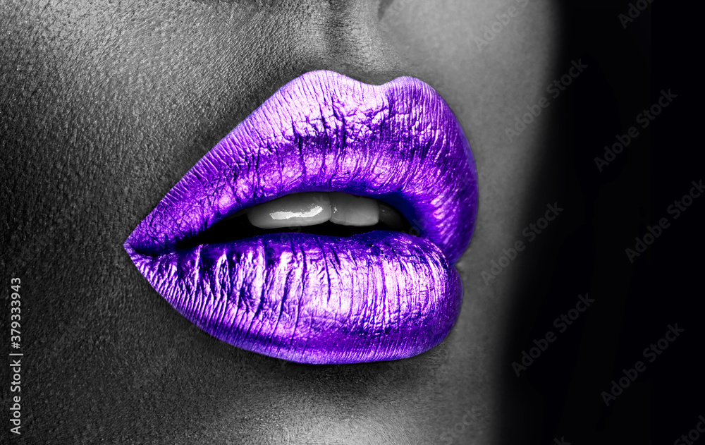 Fototapeta premium Purple lipstick closeup. Violet metal lips. Beautiful makeup. Sexy lips, bright lip gloss paint on beauty model girl's mouth, close-up. Lipstick. Black and white image