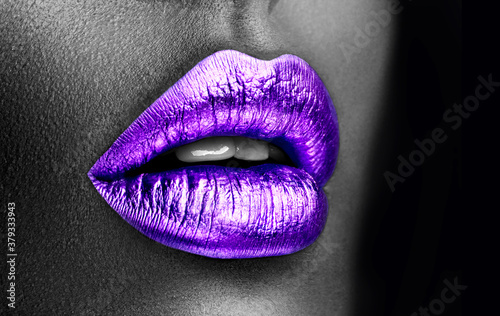 Purple lipstick closeup. Violet metal lips. Beautiful makeup. Sexy lips, bright lip gloss paint on beauty model girl's mouth, close-up. Lipstick. Black and white image