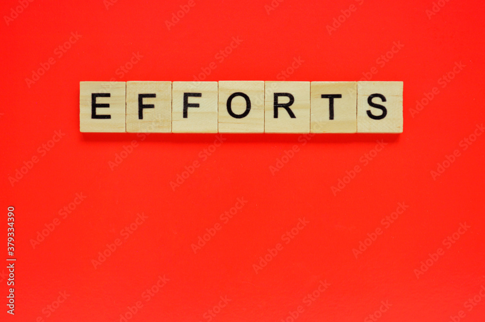 Word efforts. Wooden blocks with lettering on top of red background. Top view of wooden blocks with letters on red surface Word efforts. Wooden blocks with lettering on top of red background. Top view of wooden blocks with letters on red surface