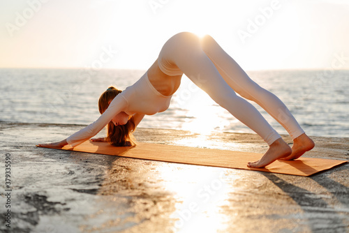 Image of sportswoman doing exercise while working out on promenade