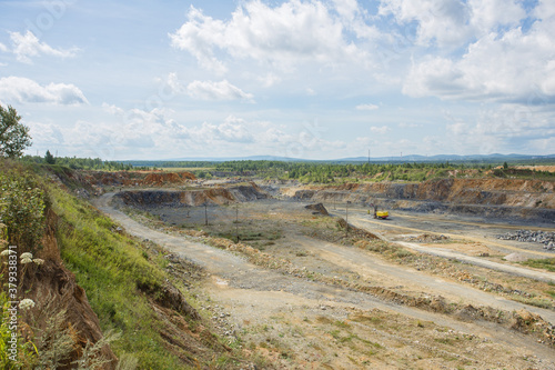 Big open pit limestone quarry mine with working drilling machines  excavators  trucks