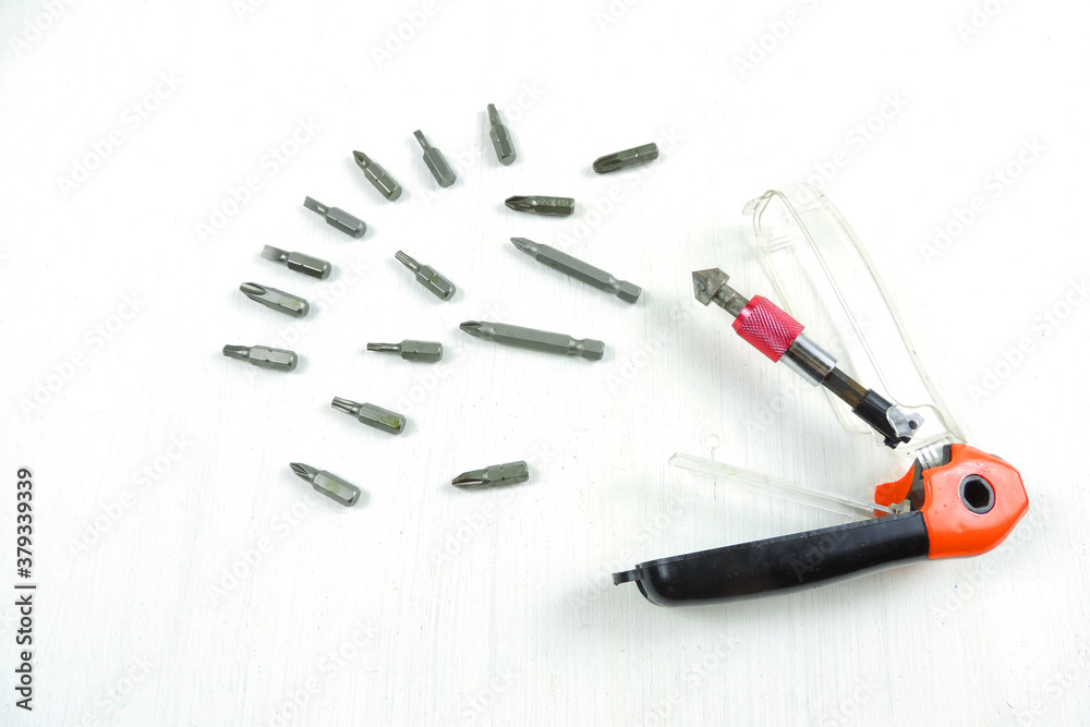 A magnetic quick release bit holder with various screw driving bits and a countersink. white background. A magnetic quick release bit holder with various screw driving bits and a countersink. white background.