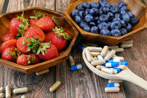 fresh natural fruits vs pills. Natural vitamin in fruits vs synthetic vitamin in pills. Choice between natural and synthetic way of health care. Alternative medicine. Dietary supplement