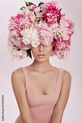 Beautiful woman with pink peony flowers, natural beauty, skin care. Perfect facial features. Girl posing on a light background © angel_nt