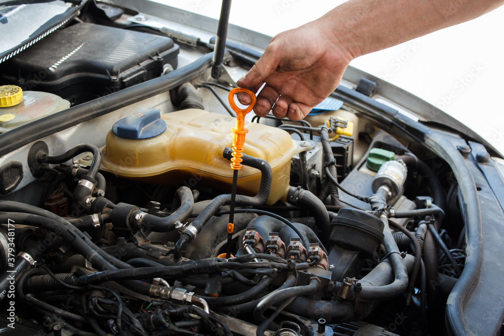 man independently checks the oil level in the car. DIY car service man independently checks the oil level in the car. DIY car service