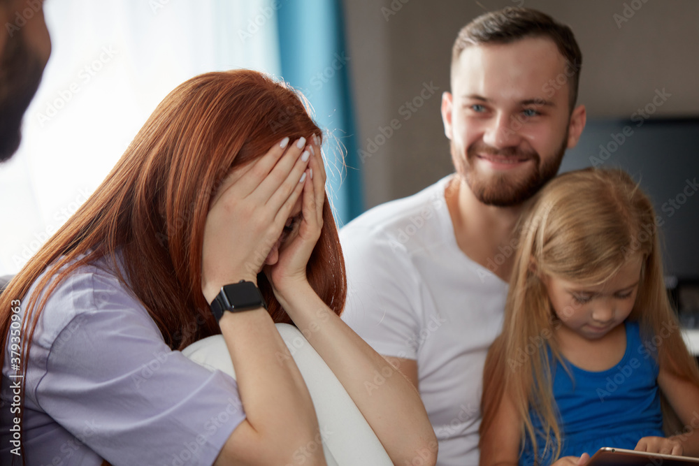 redhead woman suffering from postpartum depression, she came with daughter and husband to get psychological help, she is crying after talks redhead woman suffering from postpartum depression, she came with daughter and husband to get psychological help, she is crying after talks