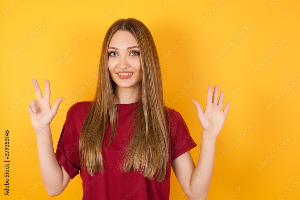 Fototapeta premium Beautiful Young beautiful caucasian girl wearing red t-shirt over isolated yellow background showing and pointing up with fingers number eight while smiling confident and happy.