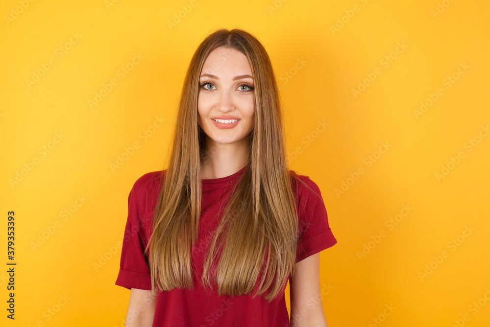 Beautiful Young beautiful caucasian girl wearing red t-shirt over isolated yellow background with a happy and cool smile on face. Lucky person.