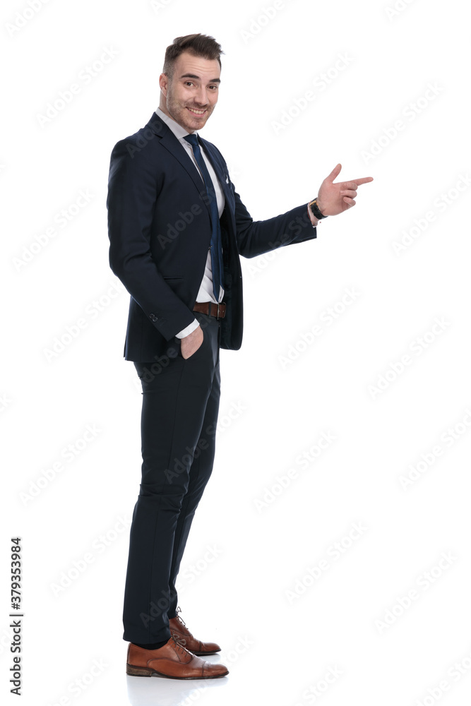 Side view of happy businessman pointing with hand in pocket Side view of happy businessman pointing with hand in pocket