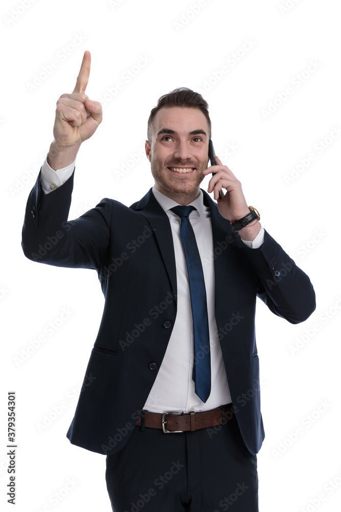 Happy businessman talking on phone, pointing up and smiling Happy businessman talking on phone, pointing up and smiling