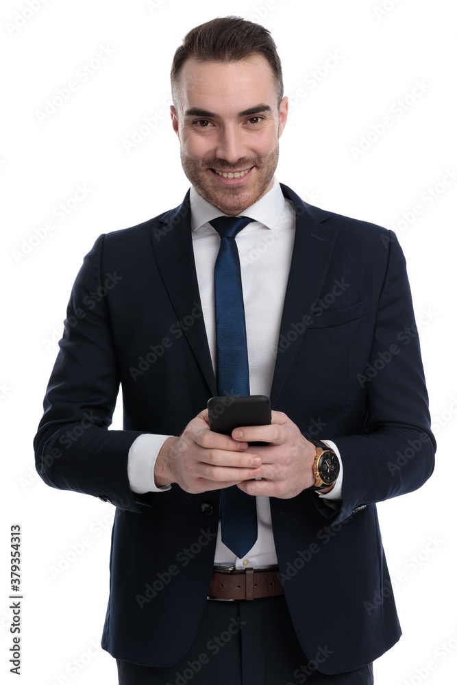 Positive businessman holding phone and smiling Positive businessman holding phone and smiling