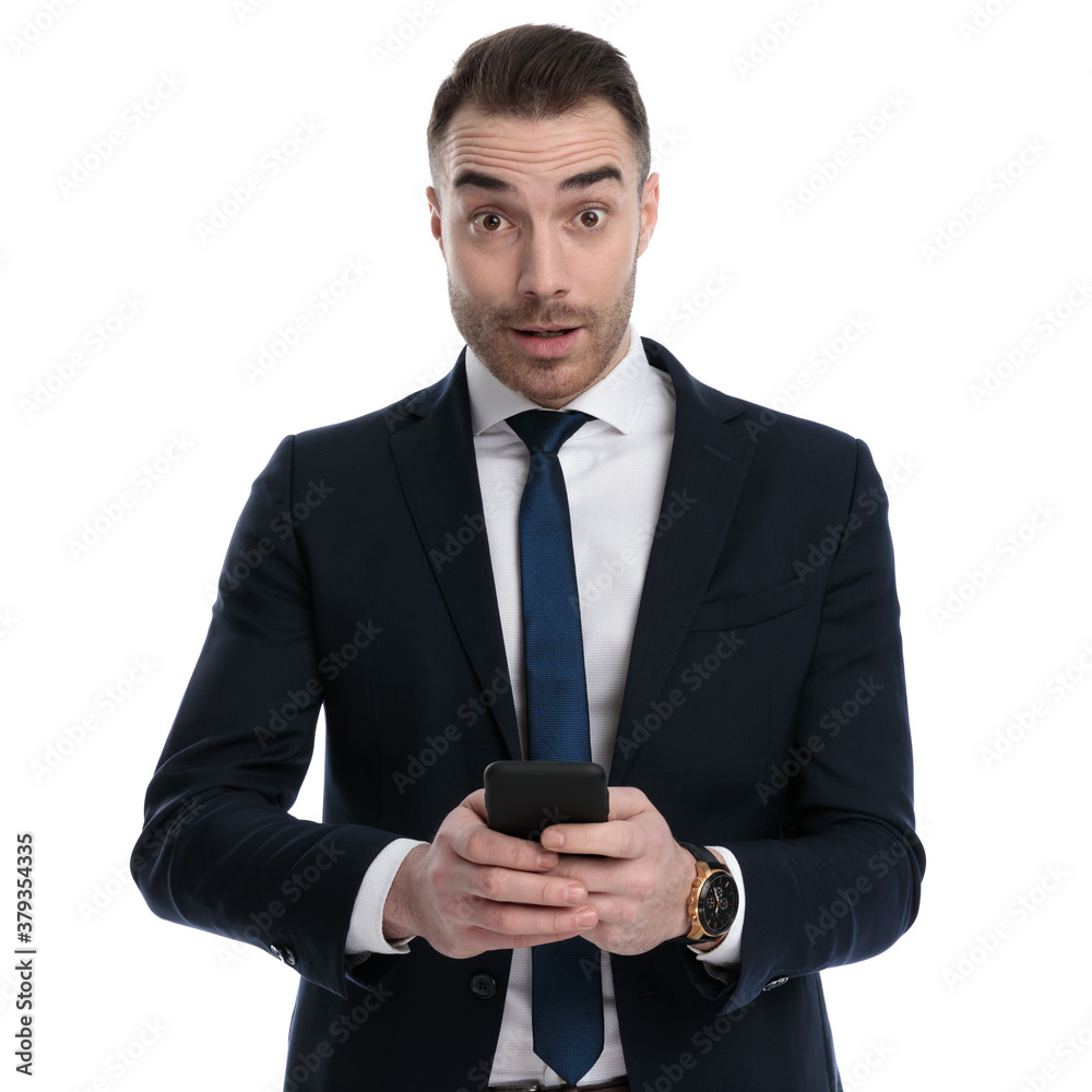 Surprised businessman smiling and holding phone Surprised businessman smiling and holding phone