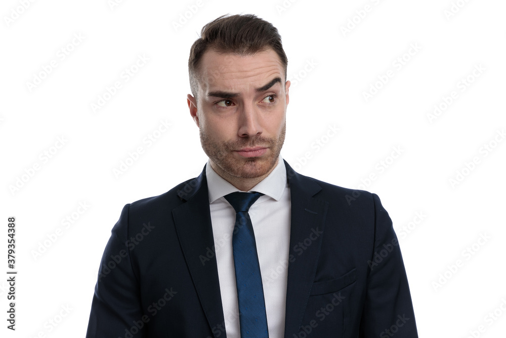 Curious businessman looking away with his eyebrow lifted Curious businessman looking away with his eyebrow lifted
