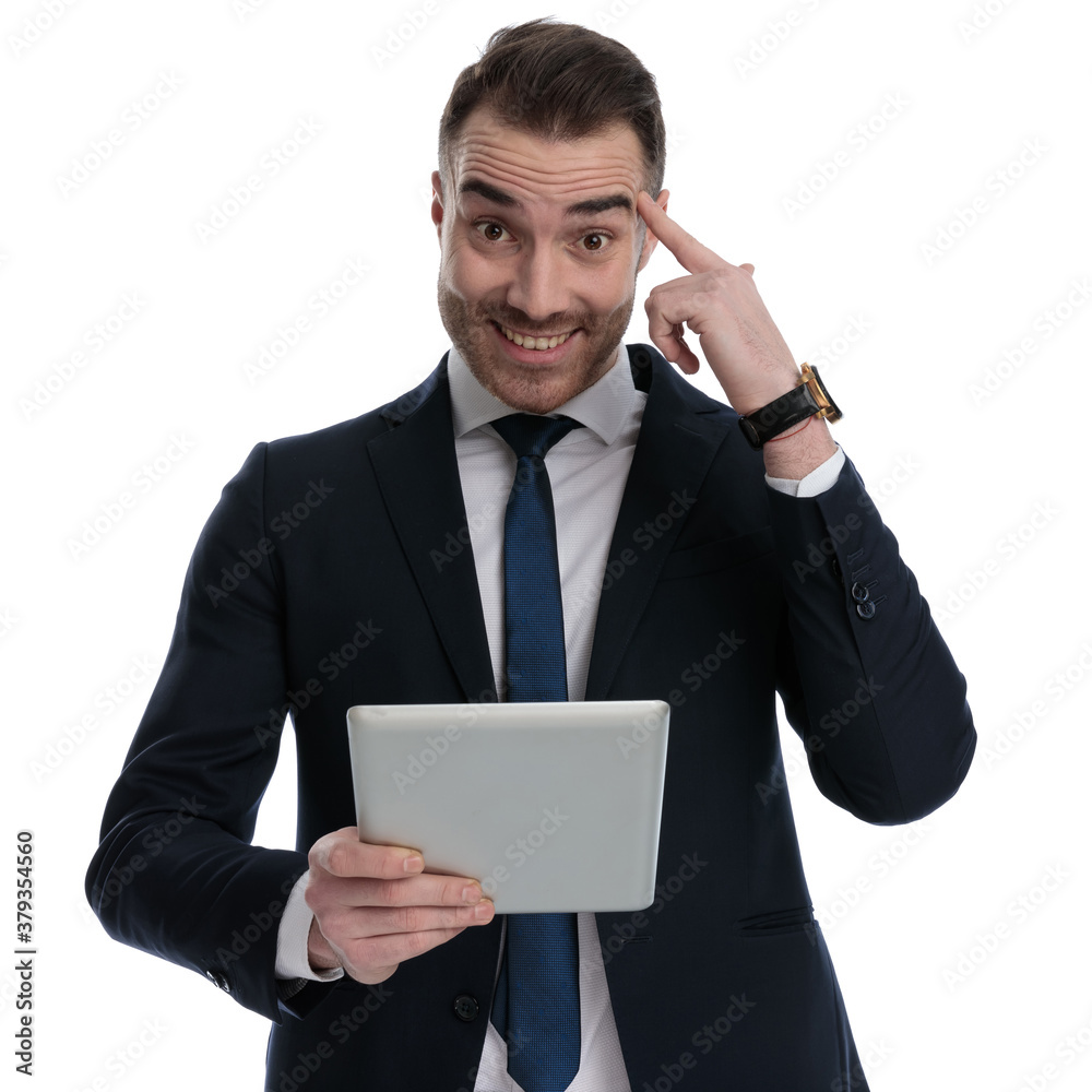 Cheerful businessman holding tablet and pointing to his forehead Cheerful businessman holding tablet and pointing to his forehead