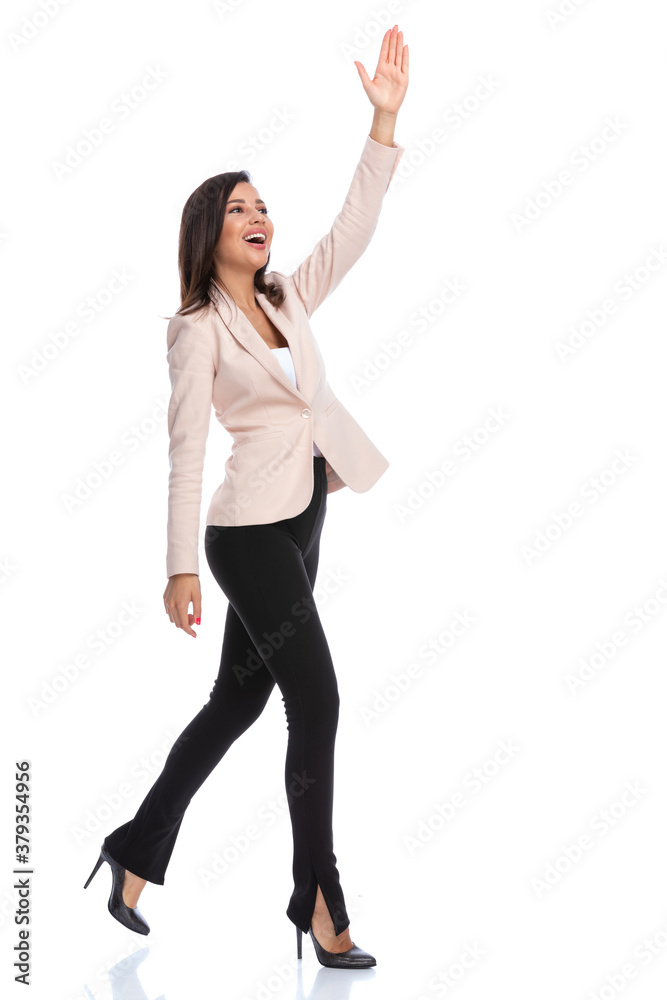 Cheerful businesswoman waving and greeting while running Cheerful businesswoman waving and greeting while running