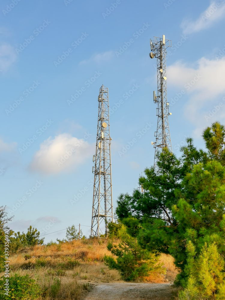 Two cellular tower on a background of a nature of countryside. Satellite communications and telecommunications.