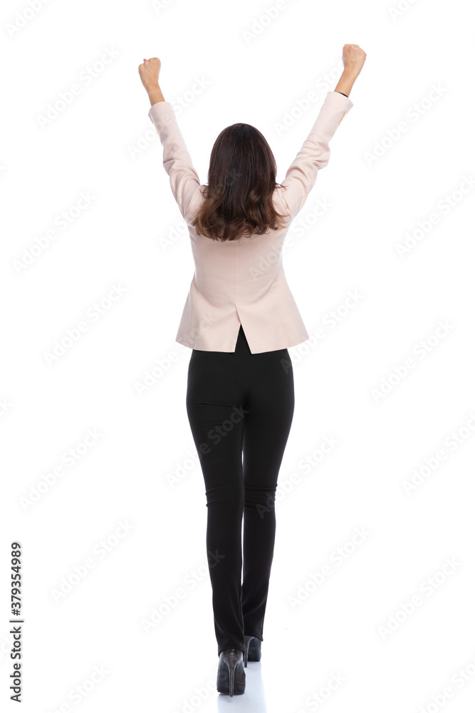 Rear view of businesswoman celebrating and walking Rear view of businesswoman celebrating and walking