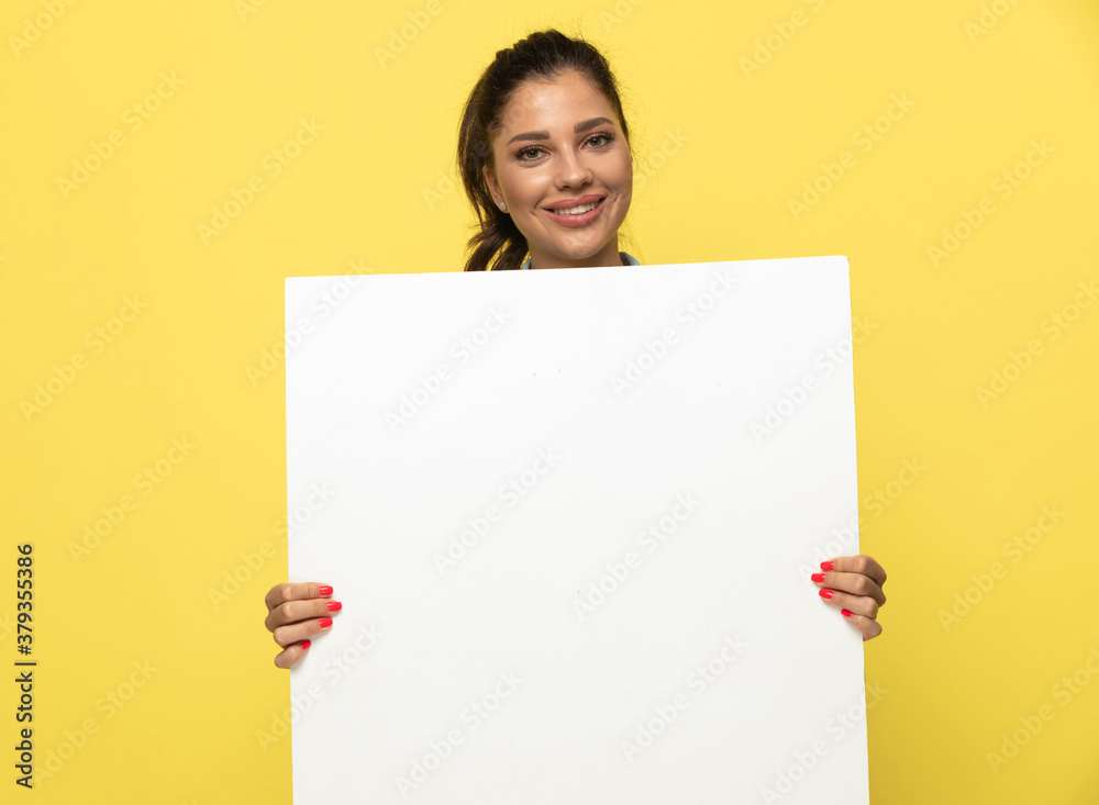 Positive casual woman holding blank newspaper and smiling Positive casual woman holding blank newspaper and smiling