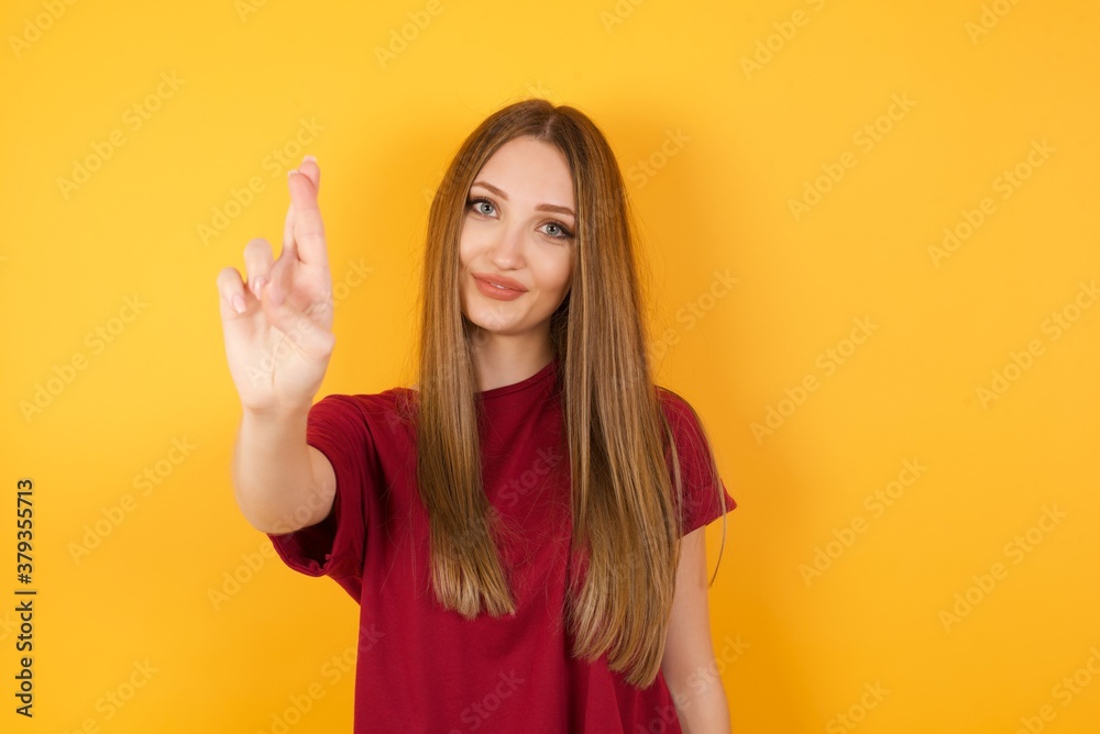 Beautiful Young beautiful caucasian girl wearing red t-shirt over isolated yellow background pointing up with fingers number ten in Chinese sign language Shi Beautiful Young beautiful caucasian girl wearing red t-shirt over isolated yellow background pointing up with fingers number ten in Chinese sign language Shi