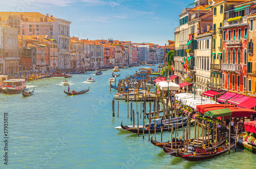 Venice cityscape with Grand Canal waterway. View from Rialto Bridge. Gondolas, boats, vaporettos docked and sailing Canal Grande. Venetian architecture colorful buildings. Veneto Region, Italy. © Aliaksandr