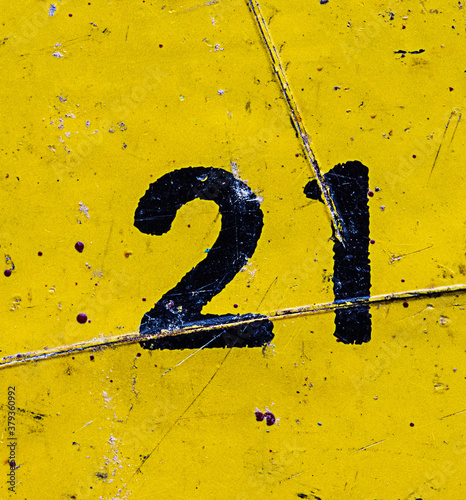 The number 21 is black on a yellow background. Grunge style, scratches and scuffs photo