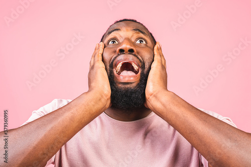 Surprised amazed african american man guy in casual isolated on pink background studio portrait. People lifestyle concept. Mock up copy space. Keeping mouth open.
