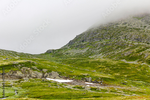 Fog, clouds, rocks and cliffs on Veslehødn Veslehorn mountain, Norway. photo