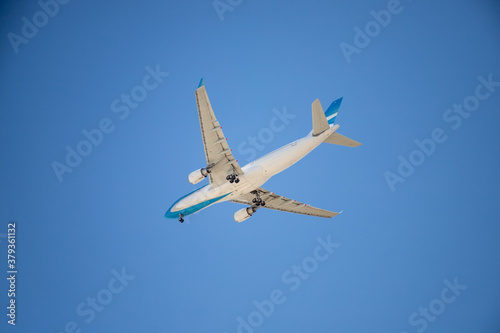 Commercial airplane flying with blue sky in the background