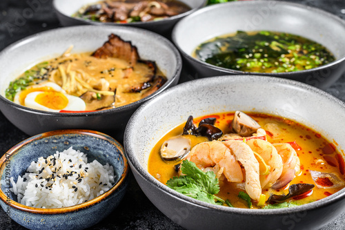 Asian soups, Miso, Ramen, Tom Yam, Pho Bo. Black background. Top view