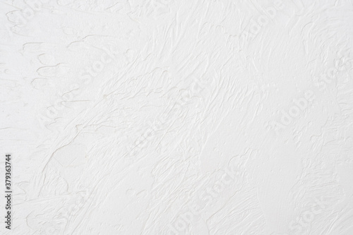 The texture of the white concrete table. White painted texture with brush and palette knife strokes for interesting and modern backgrounds.