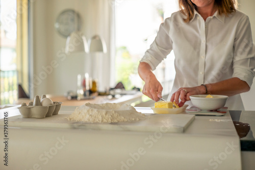 A woman making the dough for a sweet fruit tart at home in the kitchen