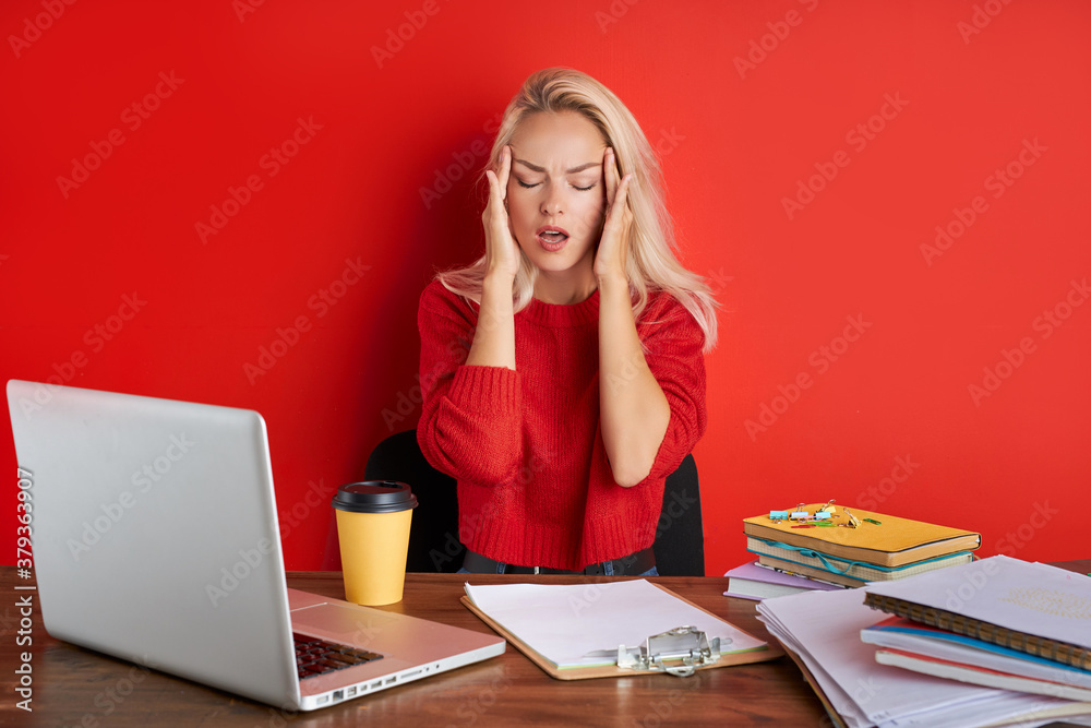 overworked unhappy and frustrated young caucasian woman in stress sitting at office desk, she has a lot of tasks in work, deadline, isolated red background overworked unhappy and frustrated young caucasian woman in stress sitting at office desk, she has a lot of tasks in work, deadline, isolated red background