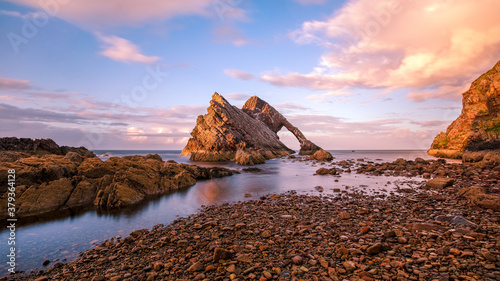 Bow Fiddle Rock (looks like a Mammut) during sunset - A natural sea arch near Portknockie on the north-eastern coast of Scotland photo