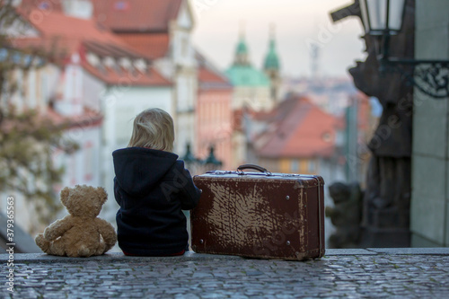 Canvas Print Beautiful child with old vintage suitcase and teddy bear, casually dressed, look