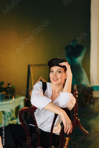 Portrait of a beautiful young woman in a white shirt and black trousers at home