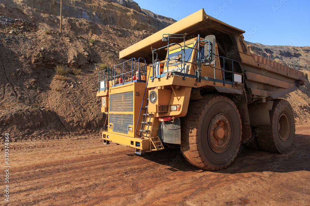 A large quarry tipper is in a red quarry