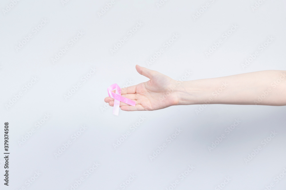 World Breast cancer day concept. Woman holds pink ribbon in her hand. October Breast Cancer Awareness month World Breast cancer day concept. Woman holds pink ribbon in her hand. October Breast Cancer Awareness month